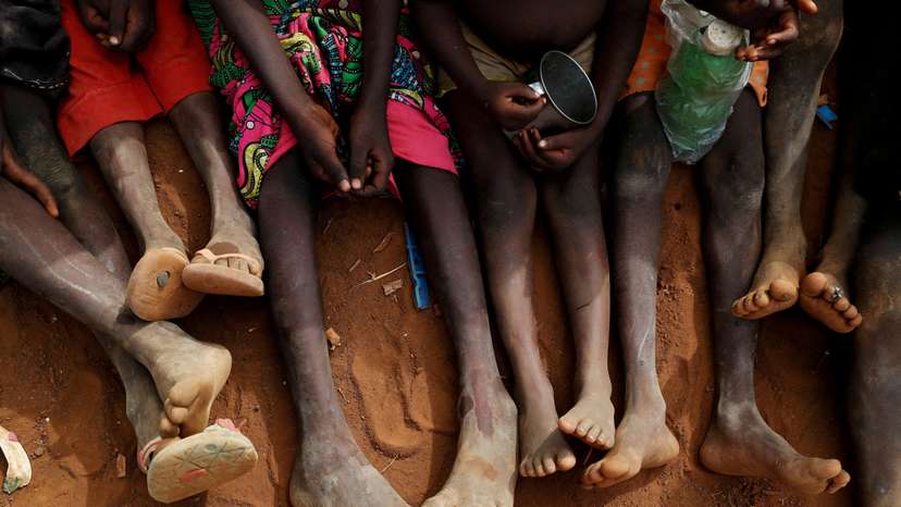 FILE PHOTO: Internally displaced orphans from Kadugli gather to eat boiled leaves at an IDP camp in South Kordofan, Sudan
