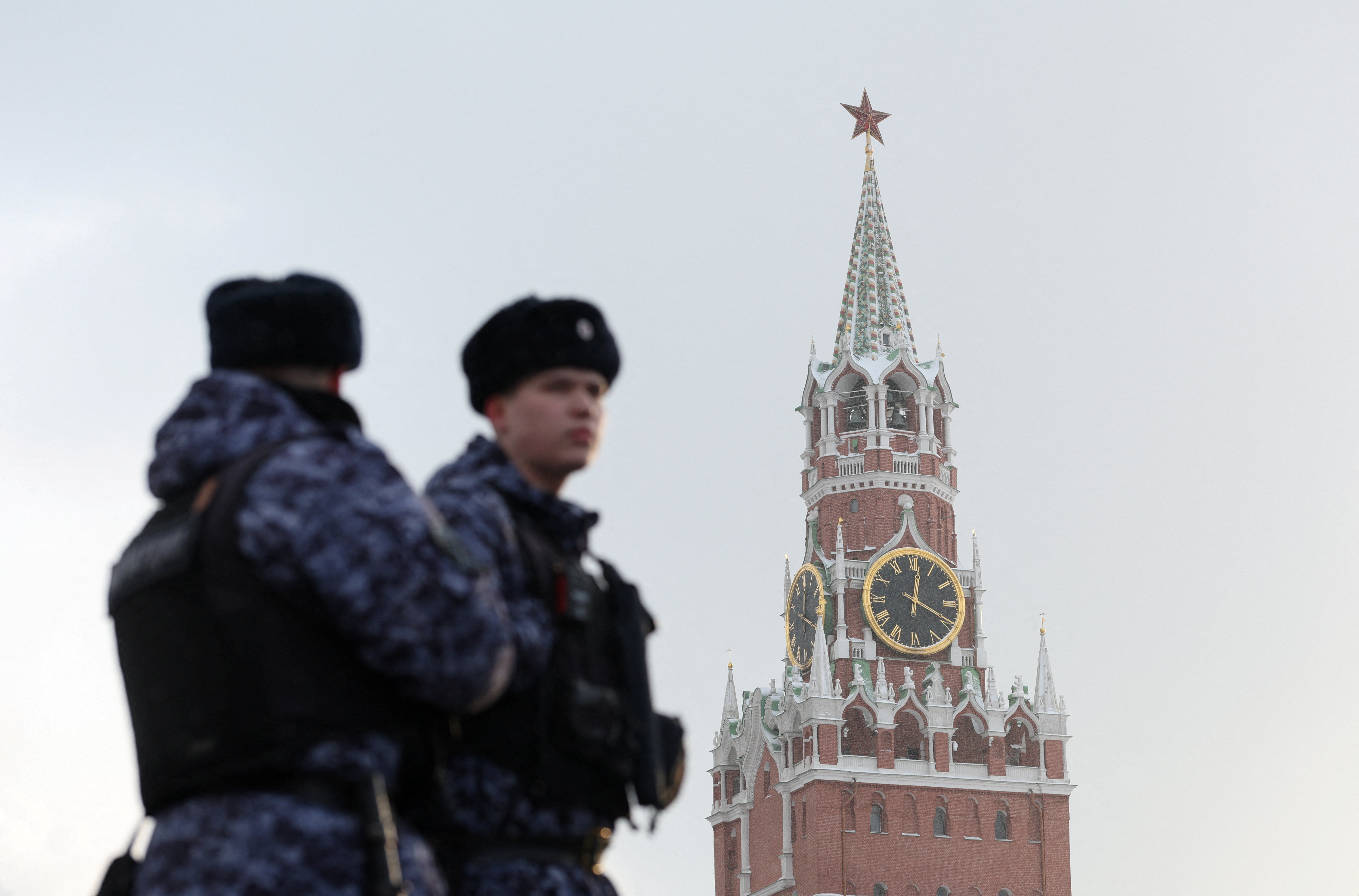 Russian law enforcement officers stand guard near Kremlin's Spasskaya Tower in Moscow