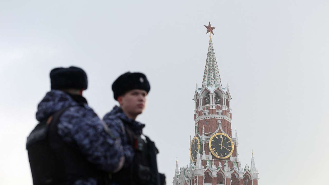 Russian law enforcement officers stand guard near Kremlin's Spasskaya Tower in Moscow