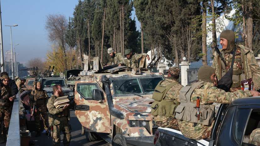 Rebel fighters sit on vehicles, in Damascus