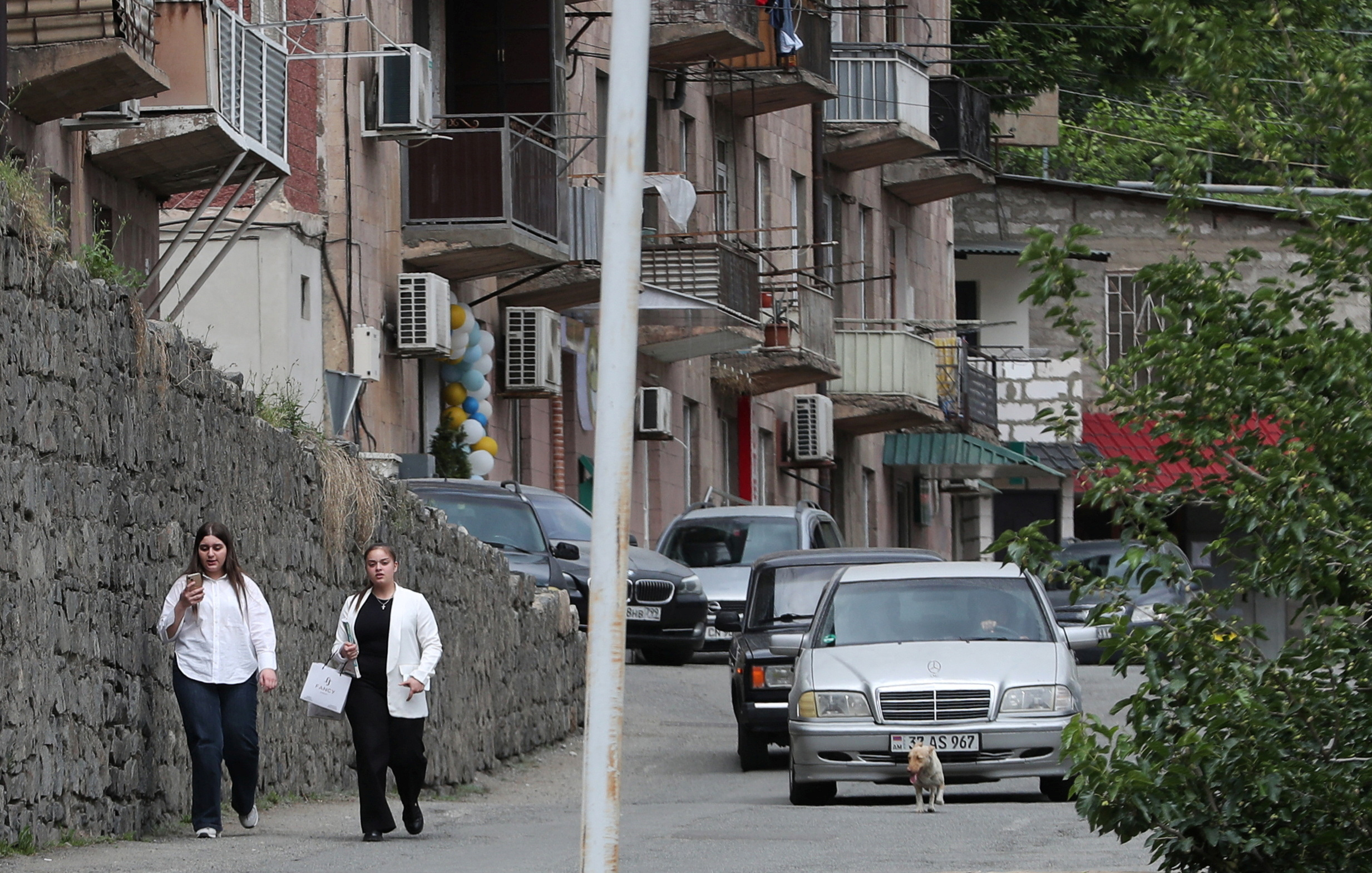 People walk along a street in Meghri