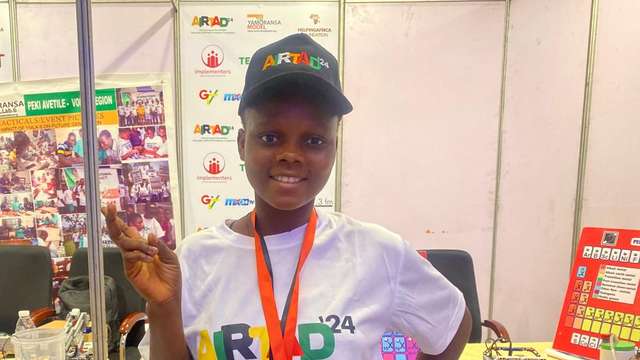 Mawuli Nutsugah in front of her team's booth at the Robotics Competition in Accra