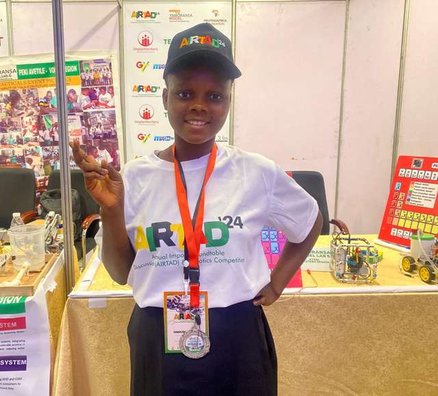 Mawuli Nutsugah in front of her team's booth at the Robotics Competition in Accra