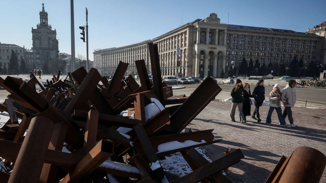 People walk down a street near anti-tank constructions in central Kyiv