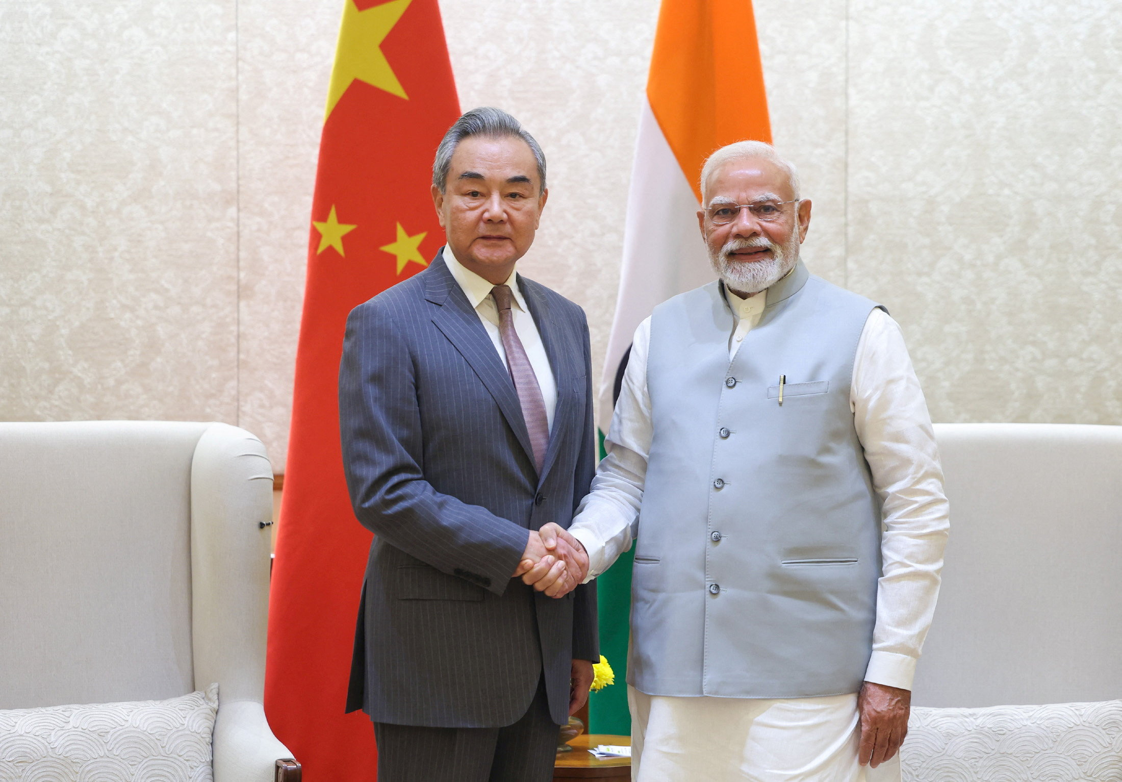 India's Prime Minister Narendra Modi shakes hand with Chinese Foreign Minister Wang Yi during their meeting in New Delhi