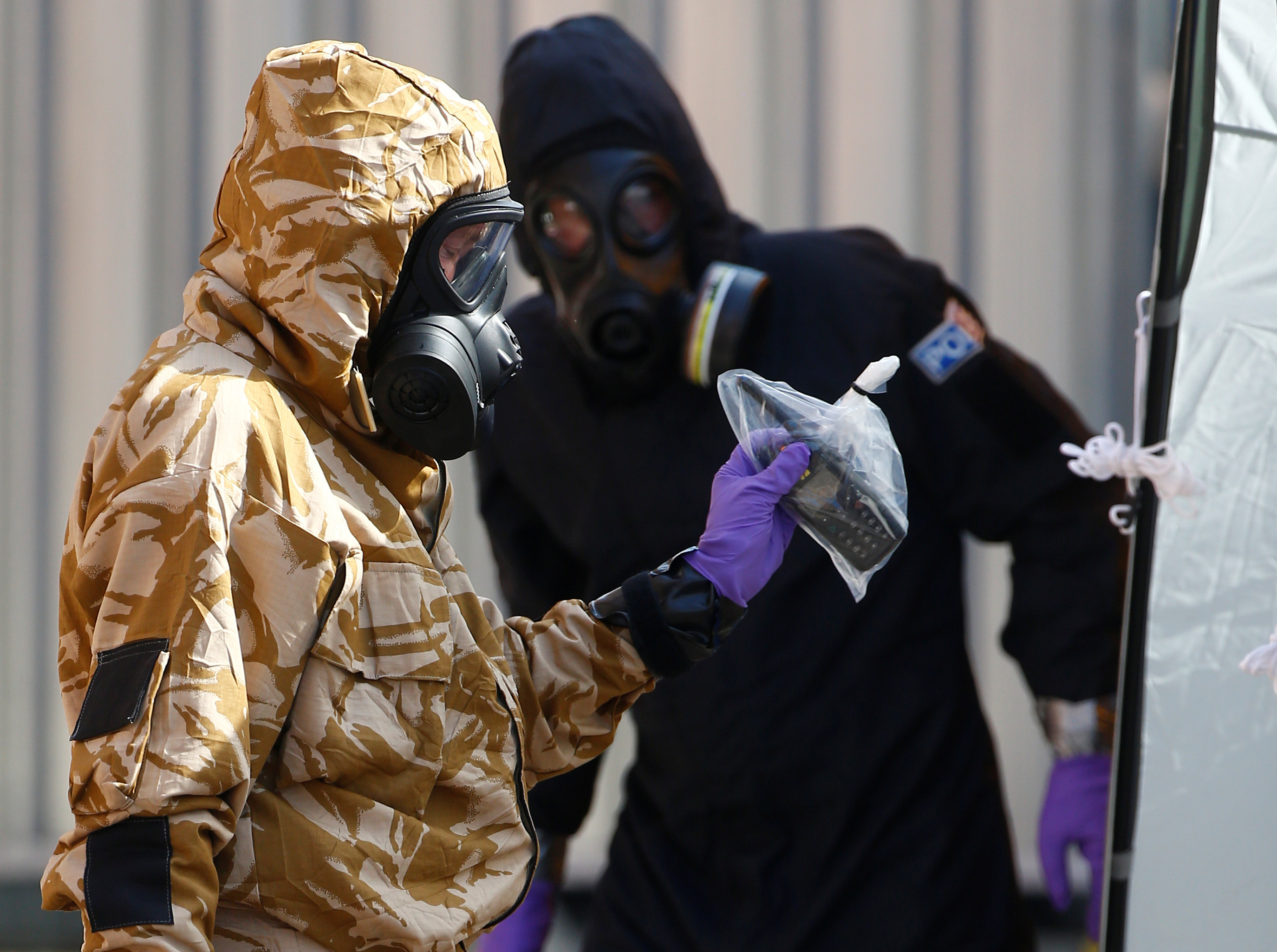 Forensic investigators, wearing protective suits, emerge from the rear of John Baker House, after it was confirmed that two people had been poisoned with the nerve-agent Novichok, in Amesbury