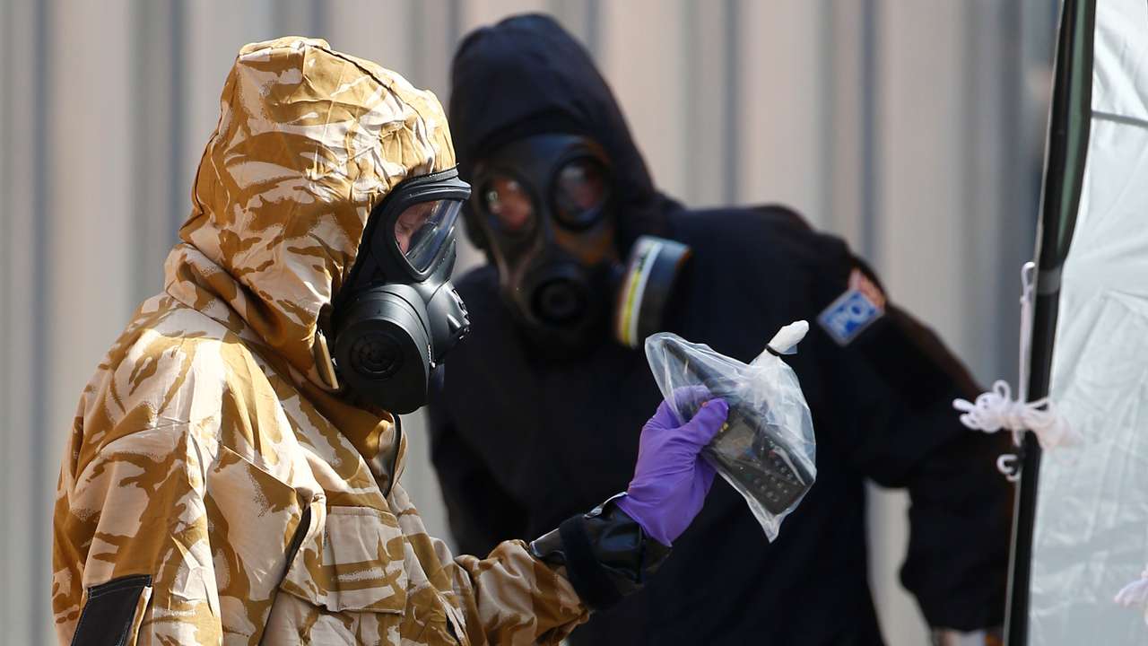 Forensic investigators, wearing protective suits, emerge from the rear of John Baker House, after it was confirmed that two people had been poisoned with the nerve-agent Novichok, in Amesbury