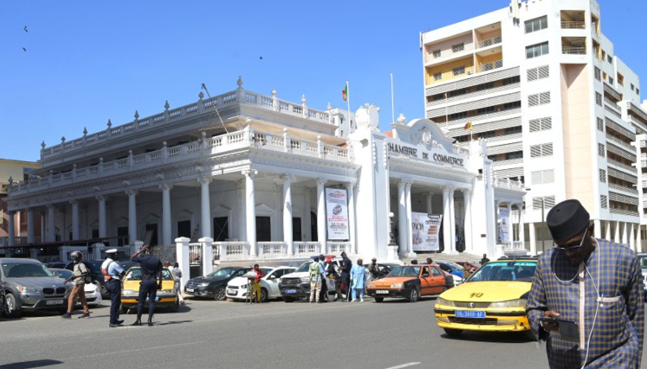 People pass walk past the Chamber of Commerce in Dakar
