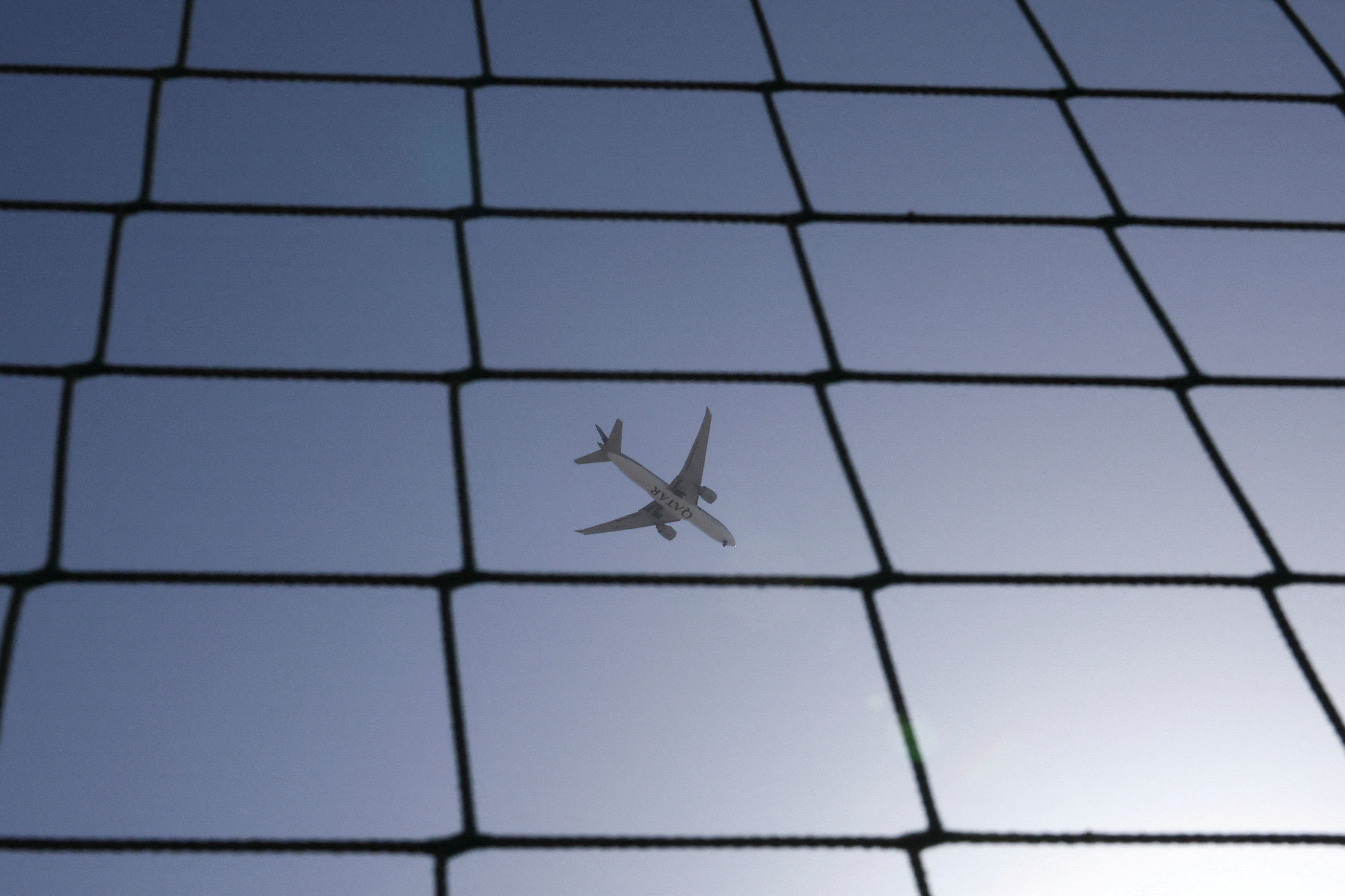 A Qatar Airways plane flies over Dubai