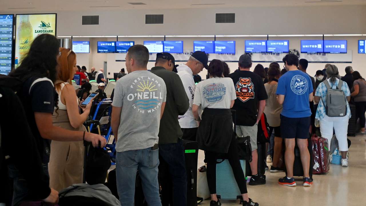 Passengers try to rebook their tickets from cancelled United Airlines flights in San Juan
