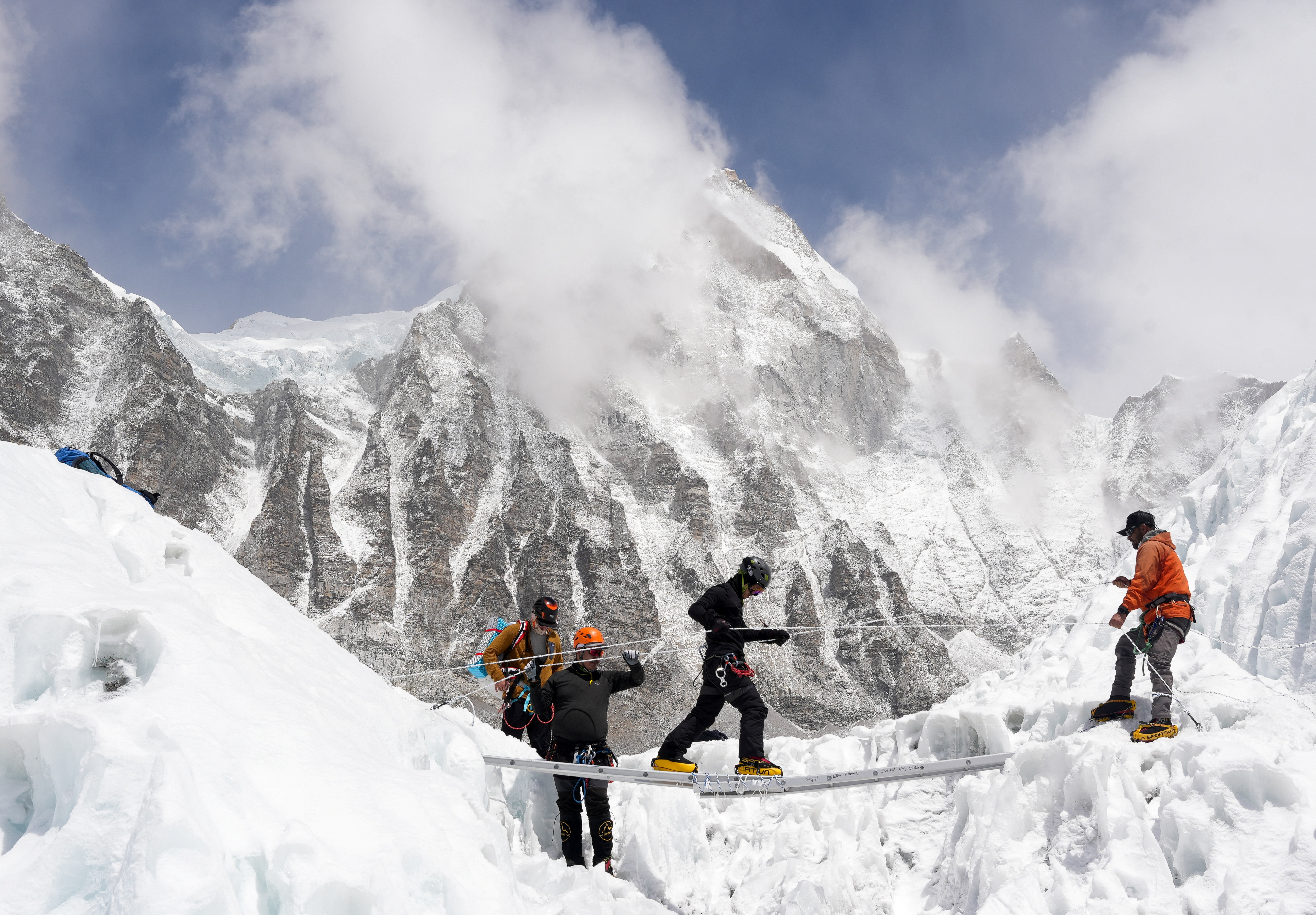 Mountaineers practice walking on a ladder during a training session at Everest base camp