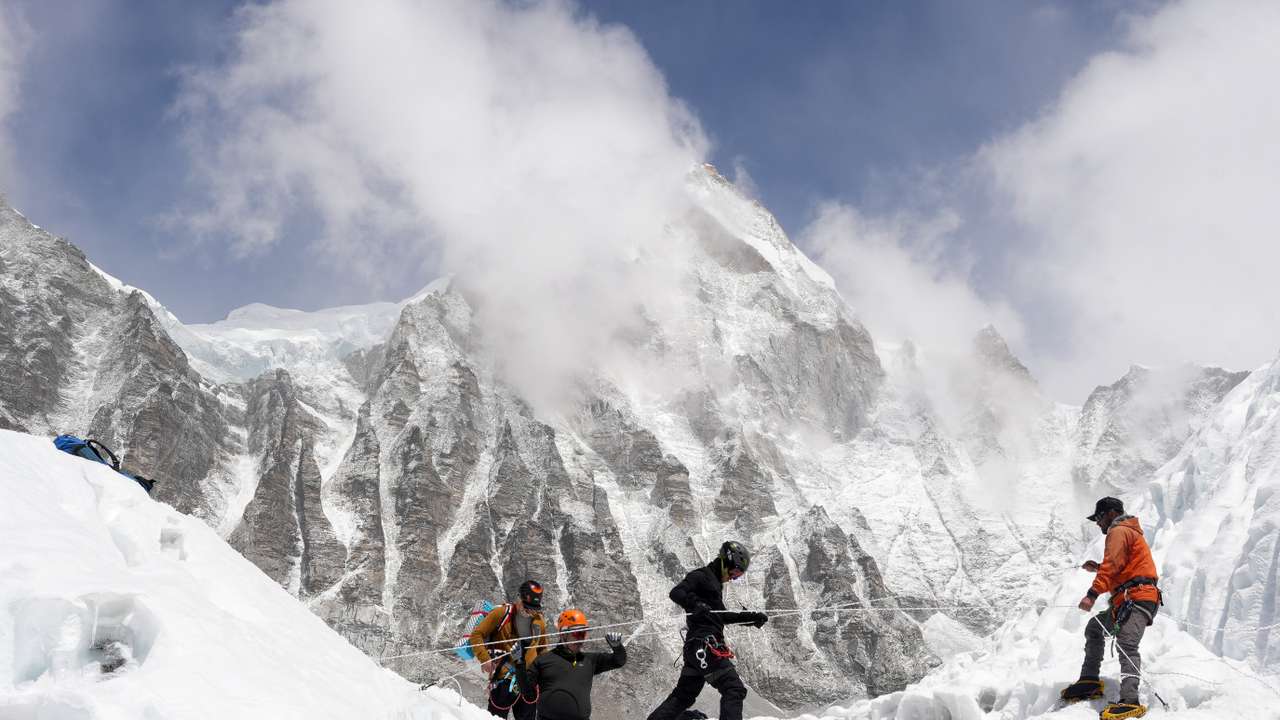 Mountaineers practice walking on a ladder during a training session at Everest base camp