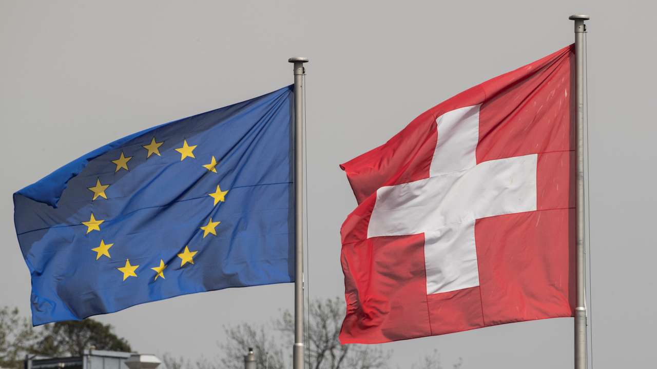 Switzerland's national flag flies beside the one of the European Union in Zurich