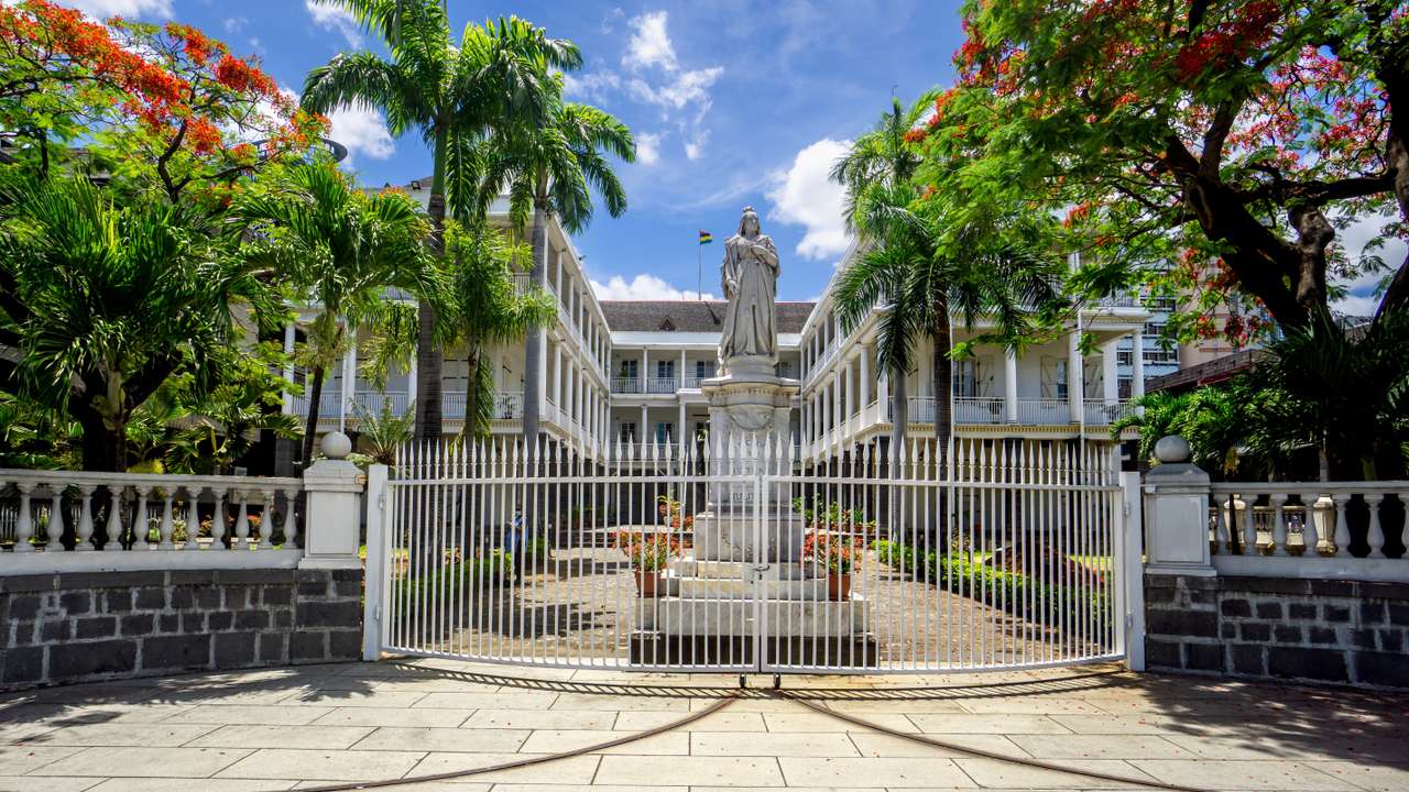 Port Louis, Mauritius, December 2021 - Main gate of the Government House, with the statue of Queen Victoria, vestige of the countrys colonial past.
