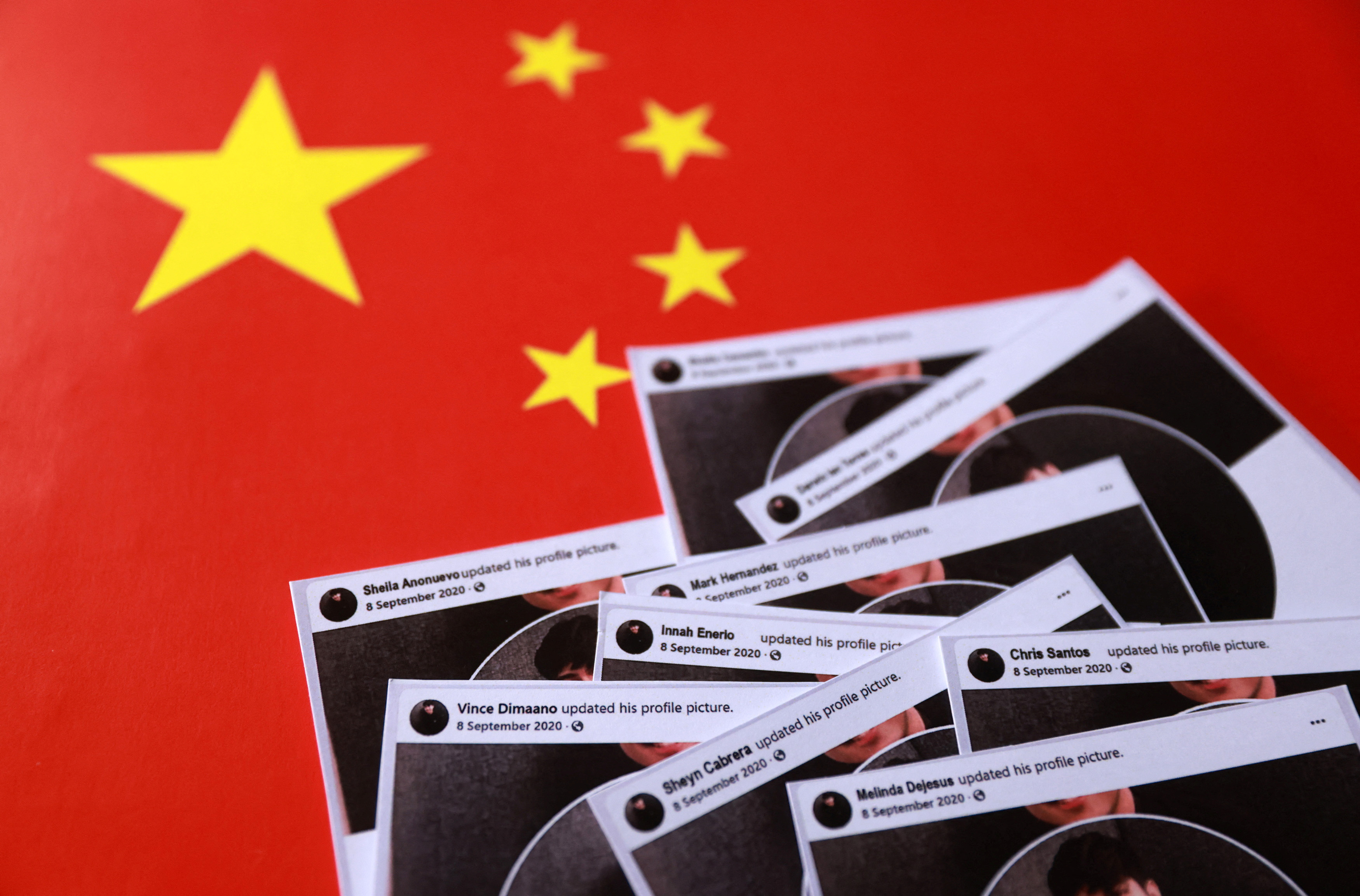 Illustration shows cut-outs of posts from fake Facebook profiles placed on a Chinese flag