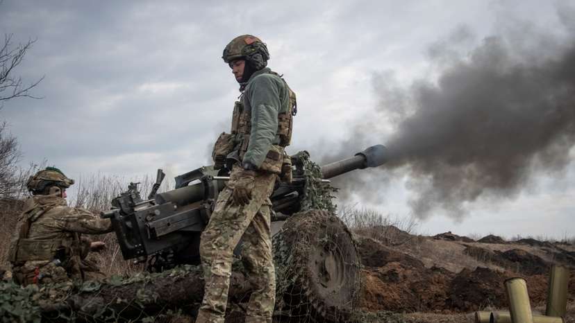 Ukrainian service members fire a howitzer M119 at a front line near Bakhmut
