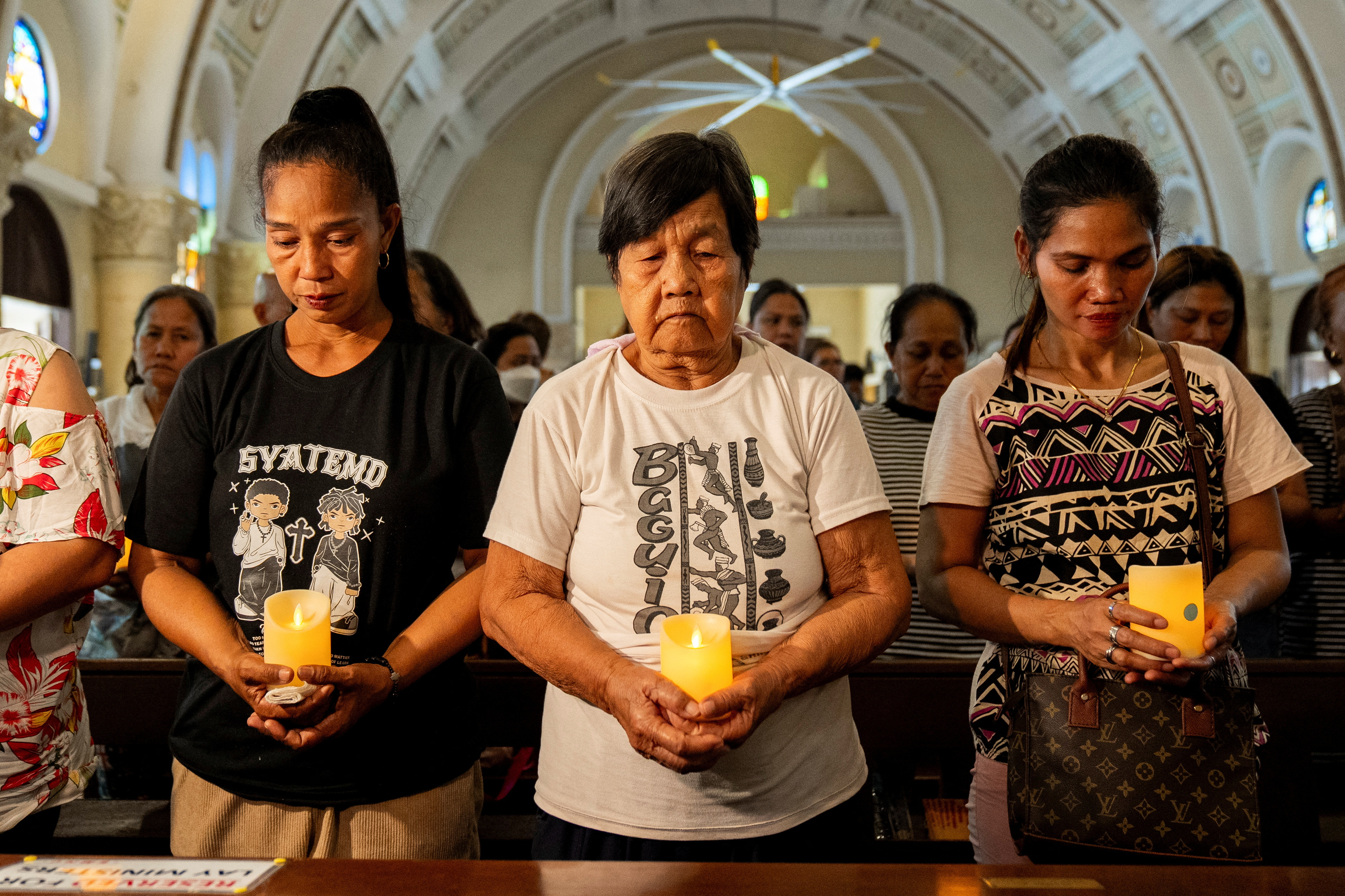 Relatives of victims of drug war and extrajudicial killings gather during a mass, in Quezon City