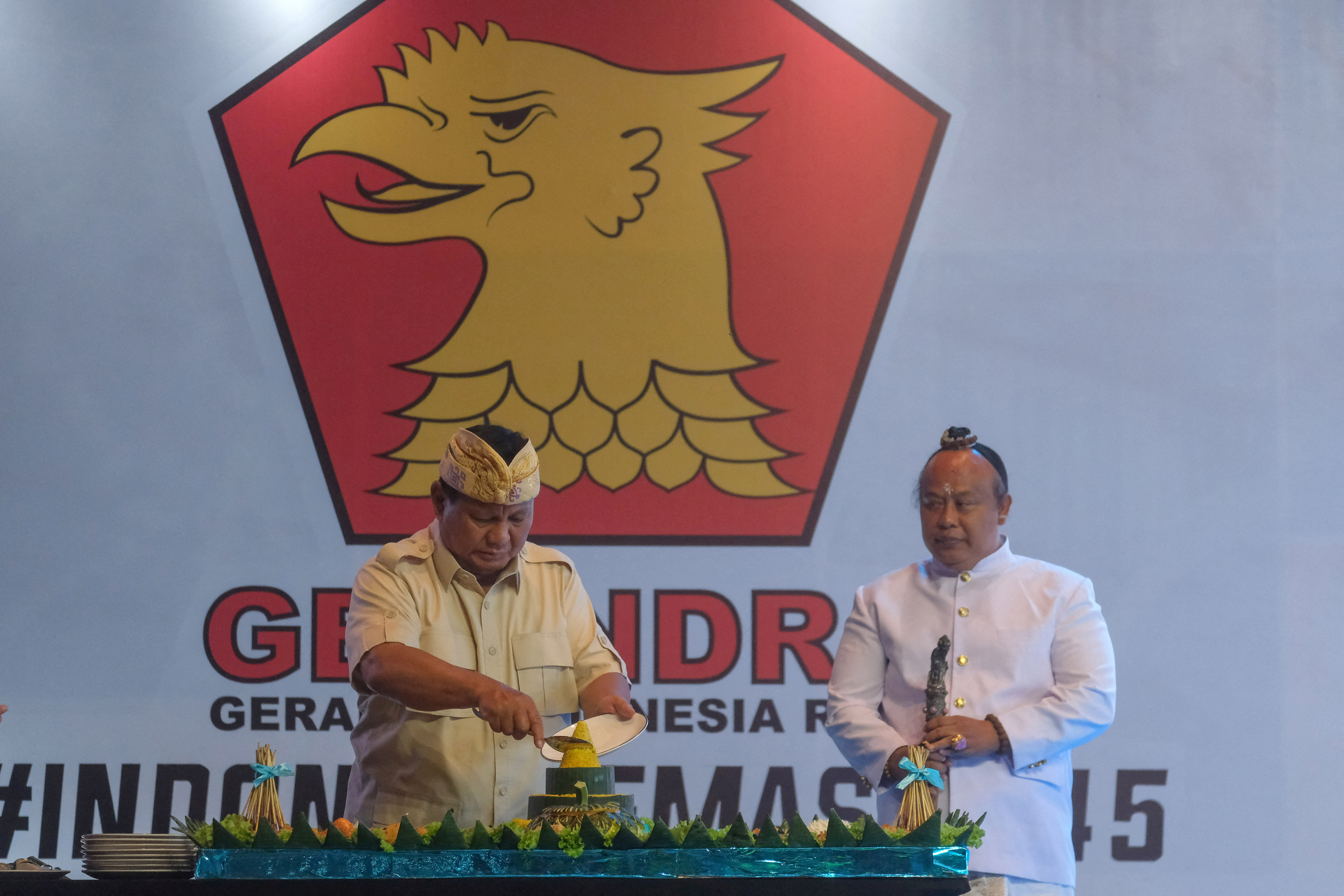 Indonesia's defence minister and presidential candidate, Subianto slices a tumpeng during the Gerindra Party anniversary in Denpasar