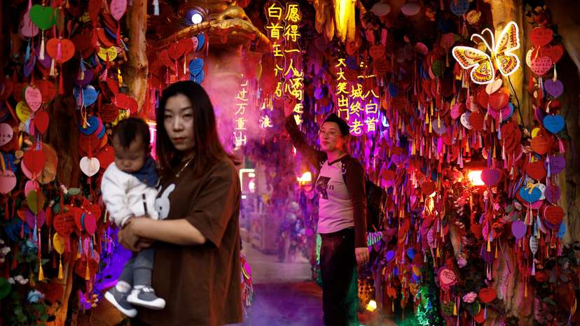 FILE PHOTO: People pose for pictures at a tourism attraction in Beijing