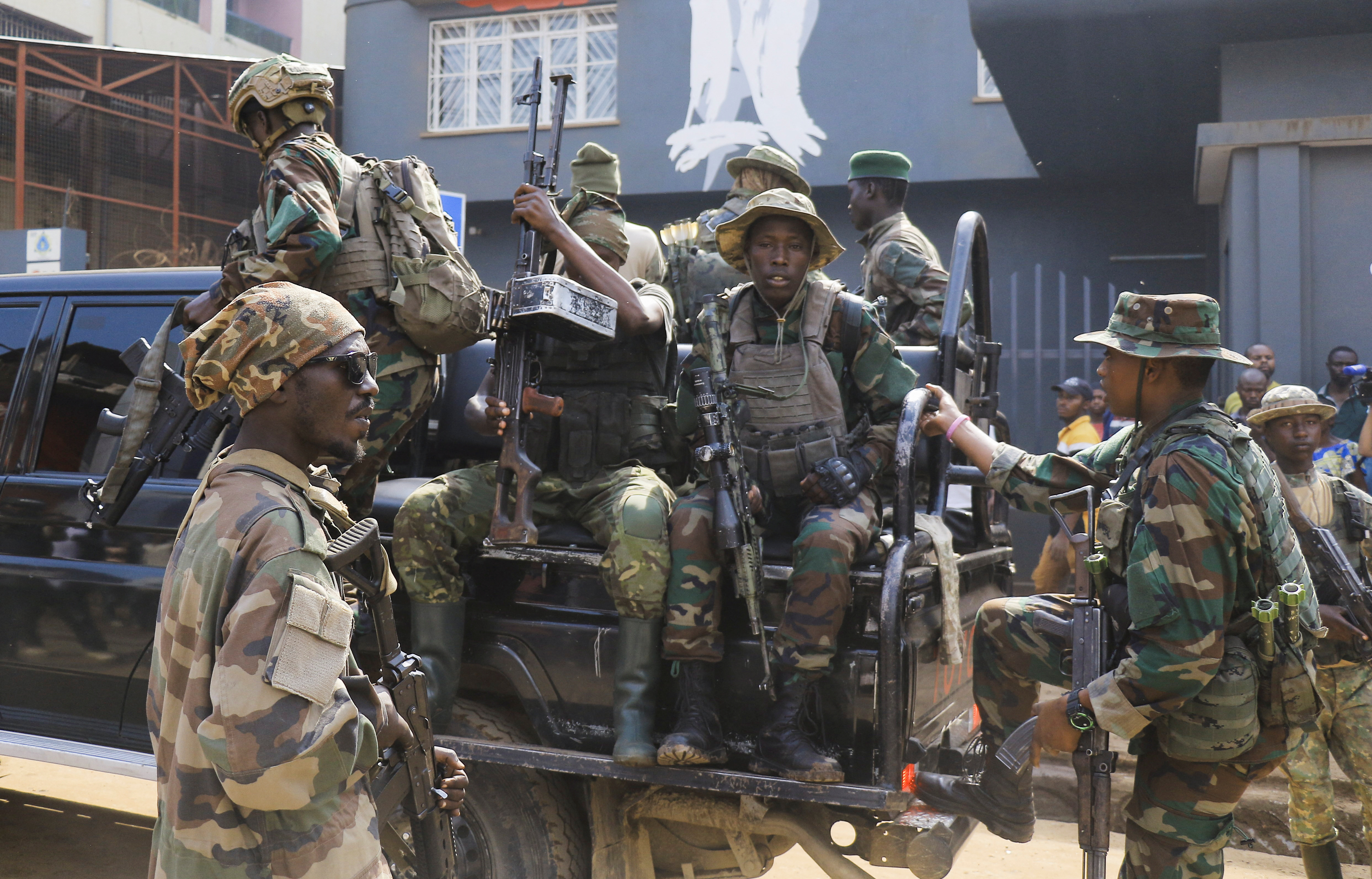 Members of the M23 rebel group gather after recovering guns during a community street cleaning exercise, following the takeover of Bukavu