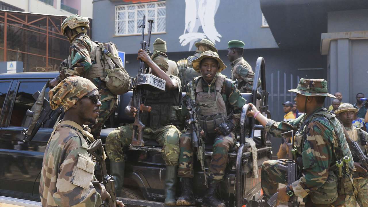 Members of the M23 rebel group gather after recovering guns during a community street cleaning exercise, following the takeover of Bukavu