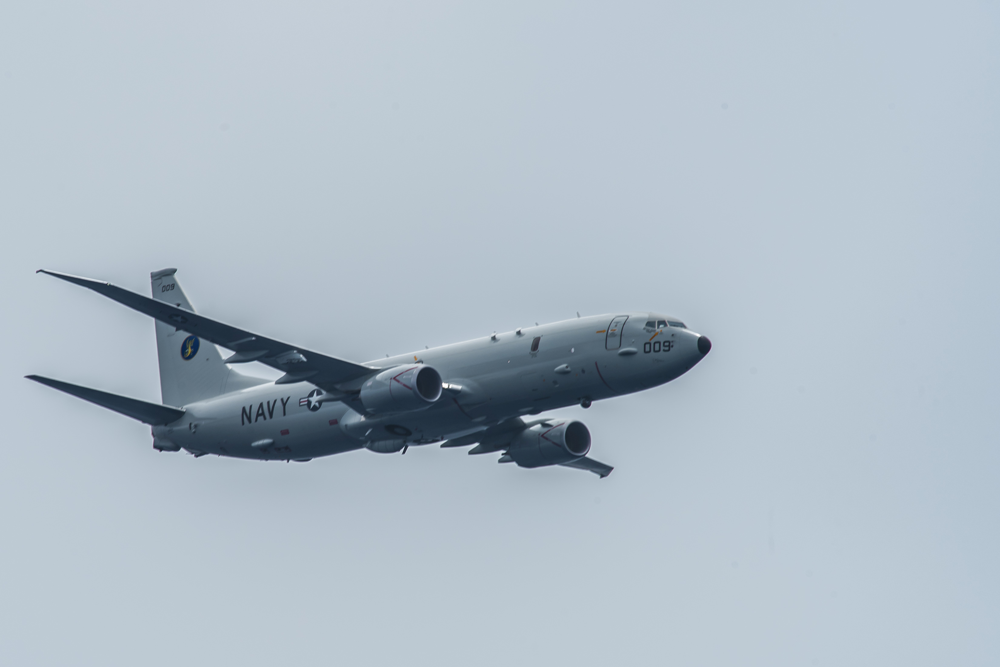 FILE PHOTO: A P-8A Poseidon assigned to the "Skinny Dragons" of Patrol Squadron (VP) 4 flies over the aircraft carrier USS Theodore Roosevelt (CVN 71) in the Pacific Ocean