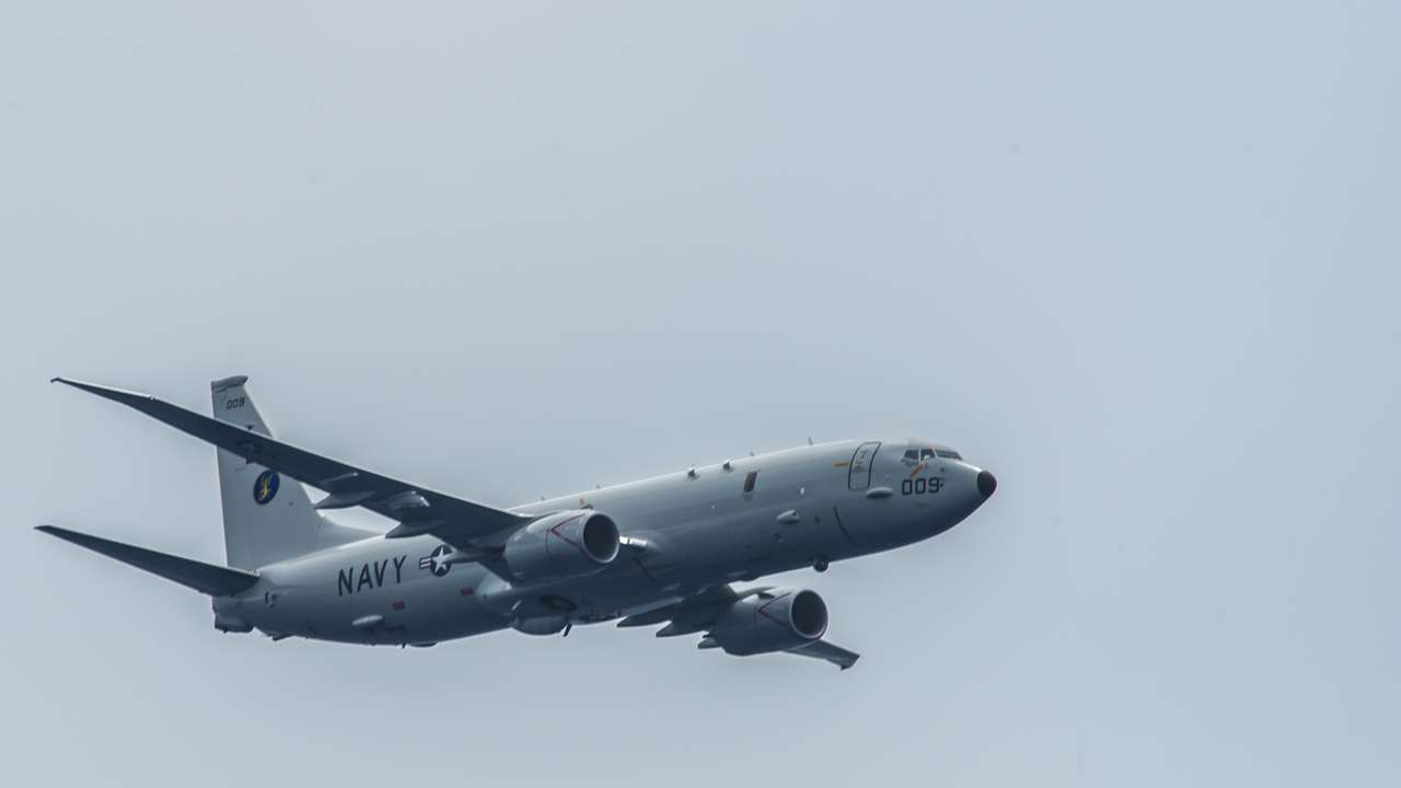 FILE PHOTO: A P-8A Poseidon assigned to the "Skinny Dragons" of Patrol Squadron (VP) 4 flies over the aircraft carrier USS Theodore Roosevelt (CVN 71) in the Pacific Ocean
