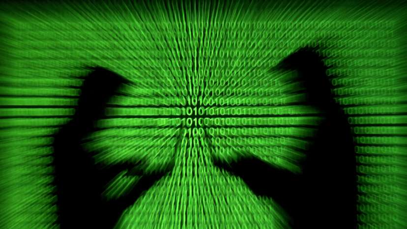 FILE PHOTO: Silhouettes of laptop users and a projection of binary code are seen in this picture illustration