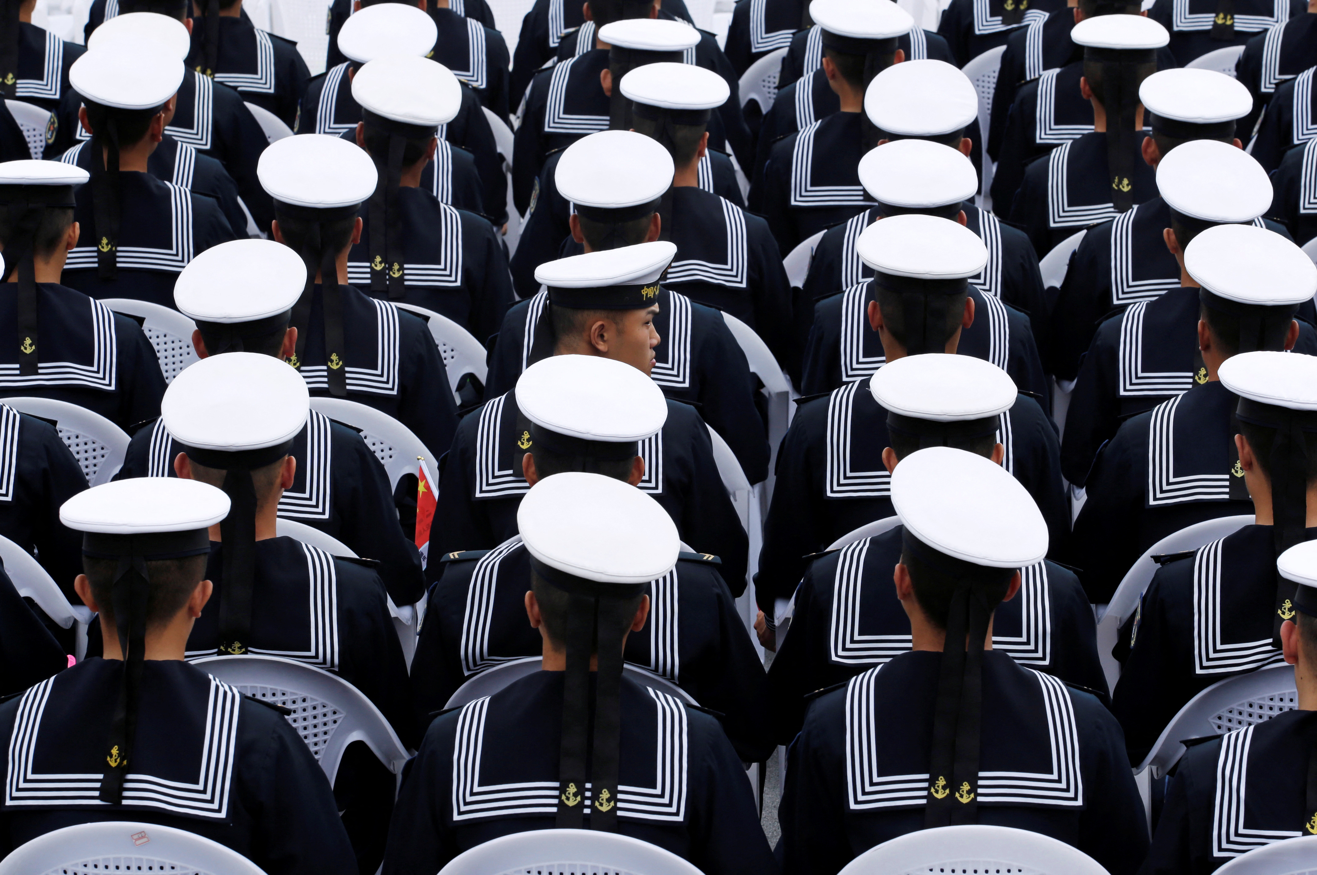 Chinese navy personnel attend an event celebrating the 70th anniversary of the founding of the Chinese People's Liberation Army Navy (PLAN) in Qingdao