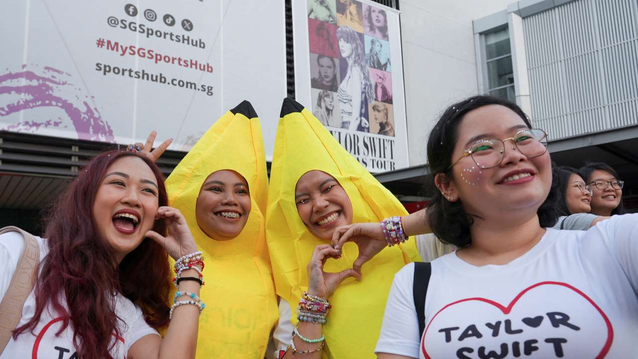 Filipina 'Swiftie' Charlyn Suizo poses for a selfie with other fans before a Taylor Swift concert, outside National Stadium in Singapore