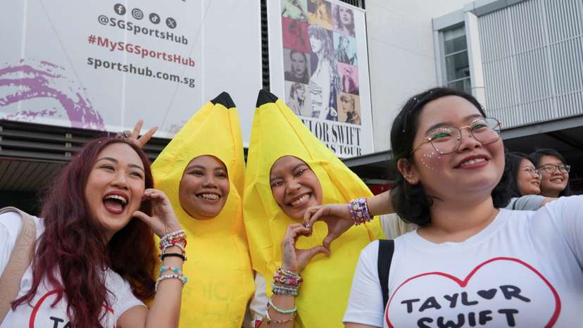 Filipina 'Swiftie' Charlyn Suizo poses for a selfie with other fans before a Taylor Swift concert, outside National Stadium in Singapore