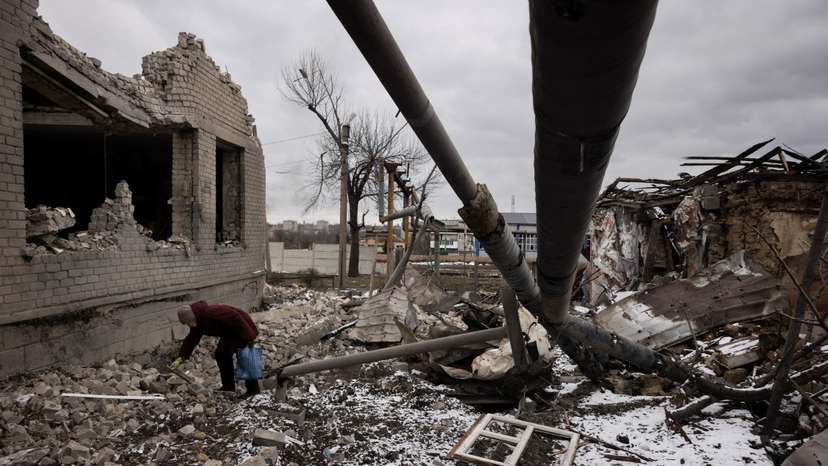 Nadezhda Prokopenko clears debris in the yard of the house of a relative that was destroyed in a Russian missile strike in Selydove near Avdiivka