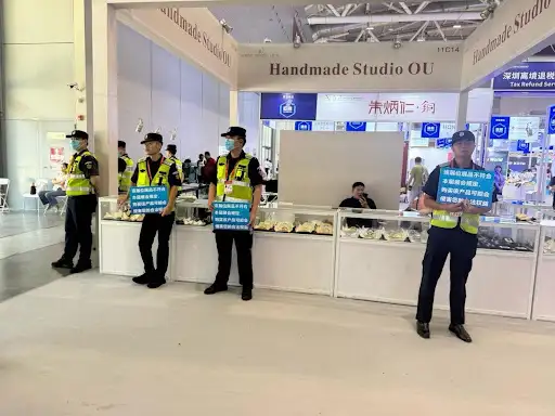 Security team holding notice saying the exhibitor had misrepresented their products