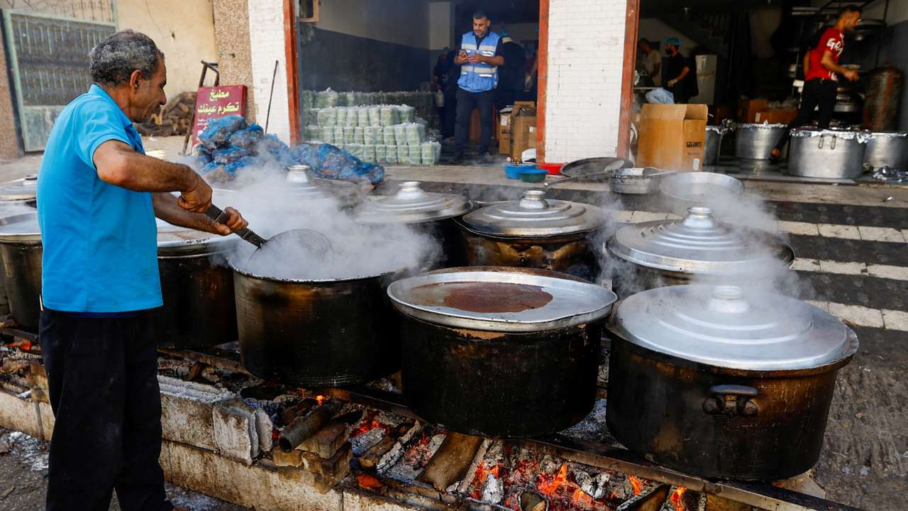 FILE PHOTO: Palestinians cook on firewood, amid fuel and cooking gas shortages, as the conflict between Israel and Hamas continues, in Khan Younis