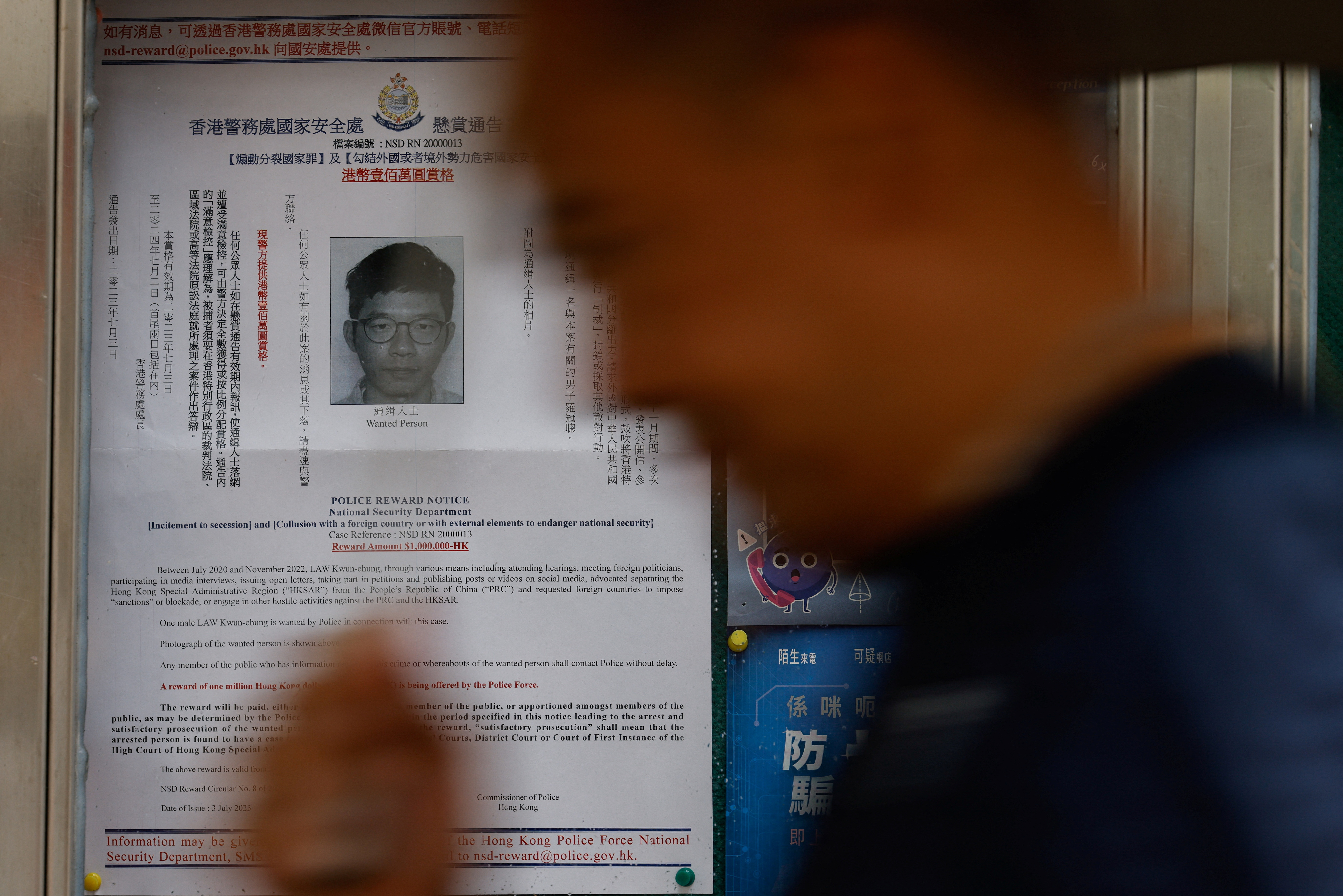 A profile of wanted exiled activist Nathan Law, is seen on a noticeboard outside a police station in Hong Kong