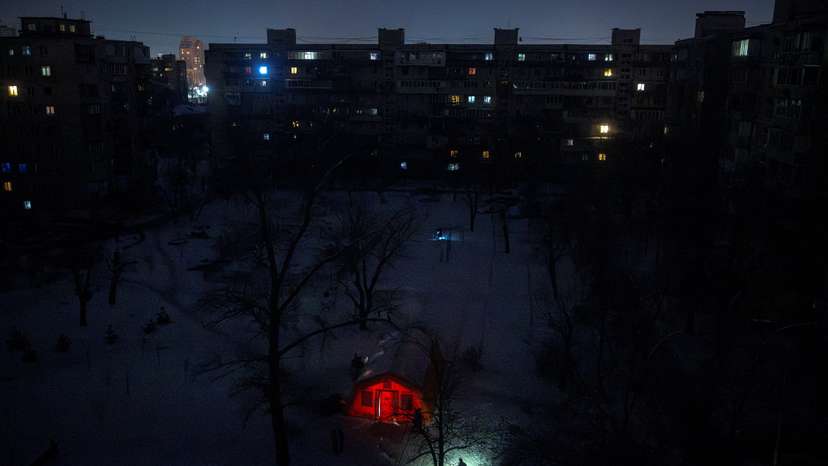 A person carrying a torch approaches a tent provided by emergency services for residents whose apartments are left without heating during sub-zero temperatures in Kyiv