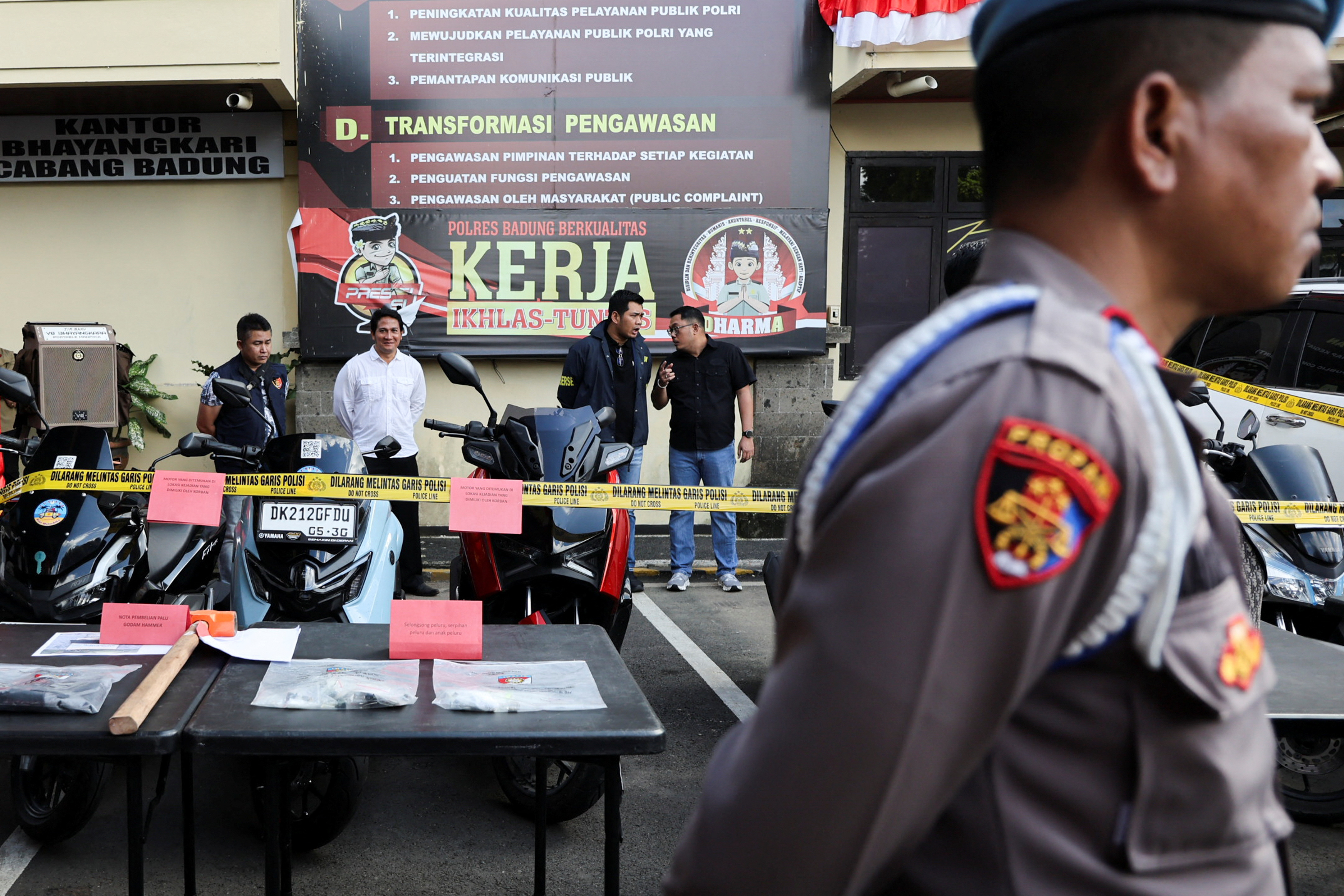 Police officers stand near evidence being displayed at the police station following a shooting incident, in Badung