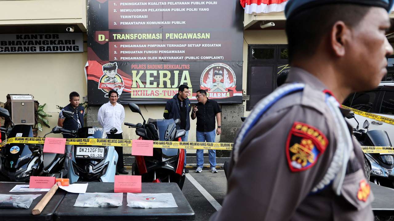 Police officers stand near evidence being displayed at the police station following a shooting incident, in Badung
