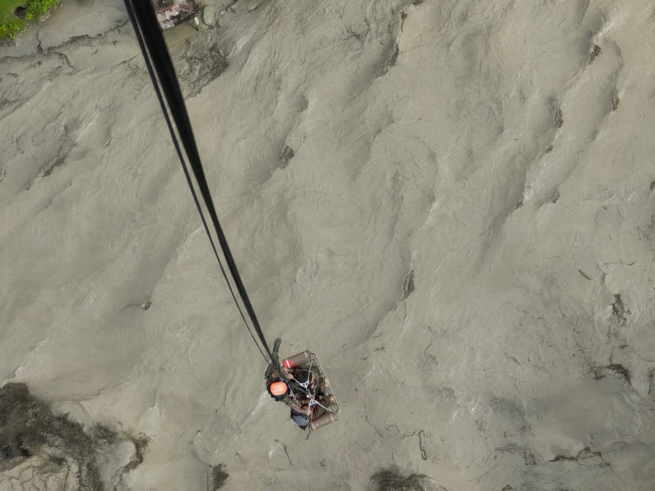 A member of the Nepalese army airlifts people stranded during the flood at Bhotekoshi river, Nepal