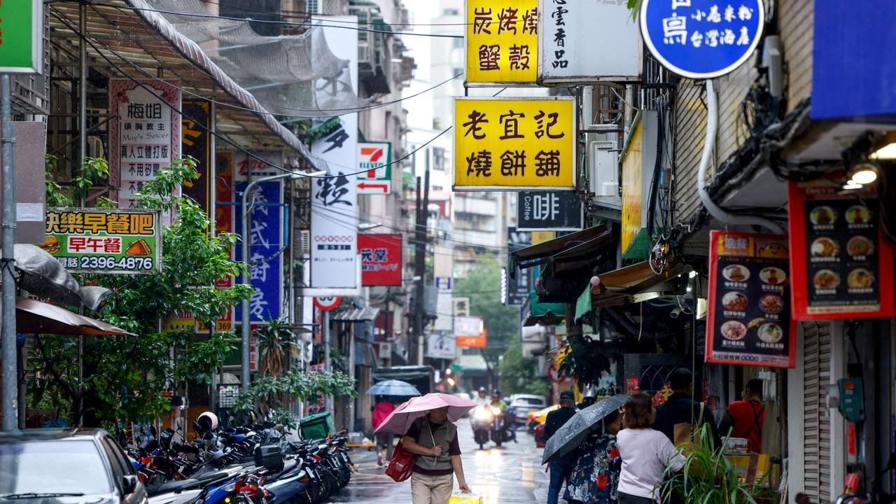A person holds an umbrella as Typhoon Fung-wong approaches in Taipei