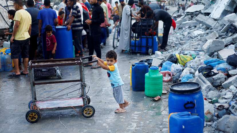 FILE PHOTO: A Palestinian child stands next to water containers, amid the ongoing conflict between Israel and Hamas, in southern Gaza City, in the Gaza Strip