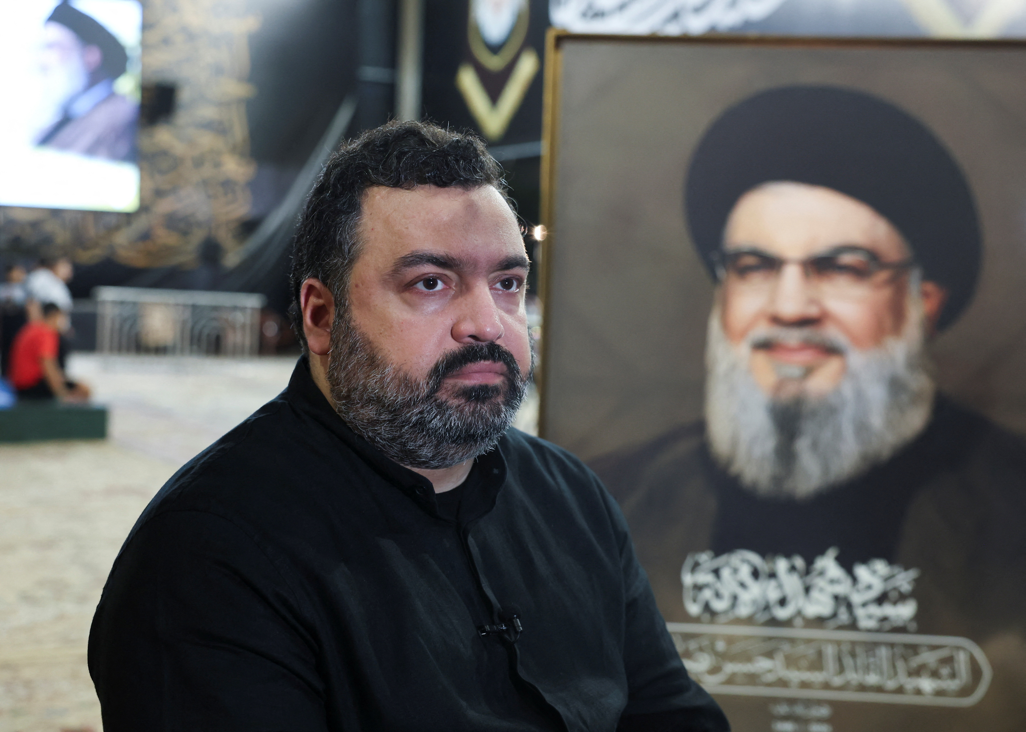 Jawad Nasrallah, son of late Hezbollah leader Hassan Nasrallah, sits at the burial site ahead of the first anniversary of his father's assassination, on the outskirts of Beirut