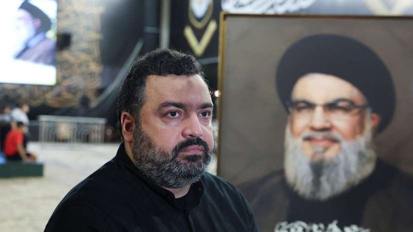 Jawad Nasrallah, son of late Hezbollah leader Hassan Nasrallah, sits at the burial site ahead of the first anniversary of his father's assassination, on the outskirts of Beirut