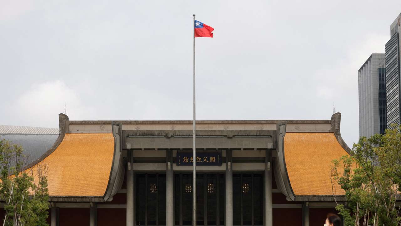 FILE PHOTO: People walk near a fluttering Taiwanese flag outside the Sun Yat-Sen Memorial Hall in Taipei