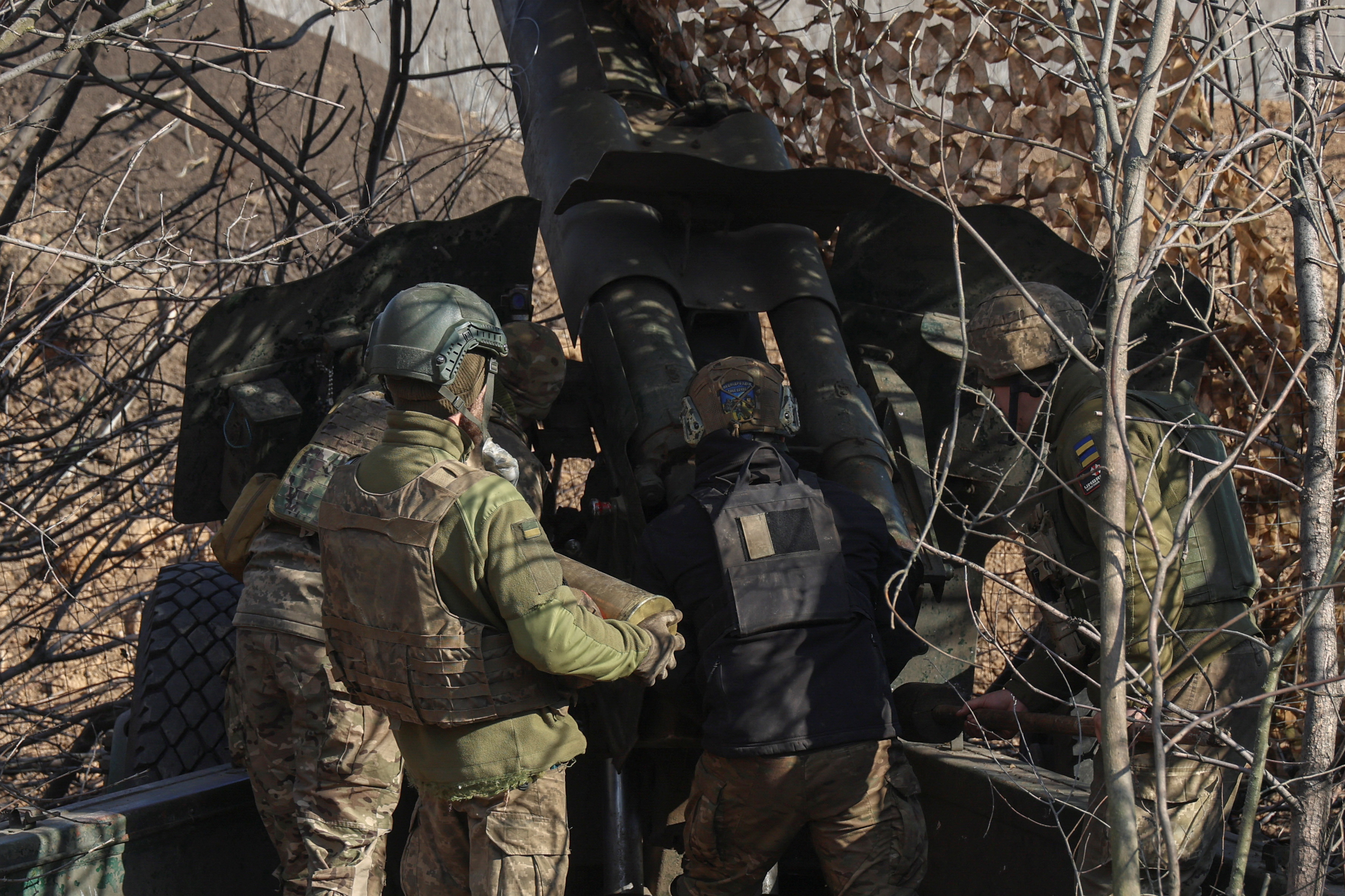 Ukrainian service members prepare a D-20 howitzer before firing toward Russian troops in Donetsk region