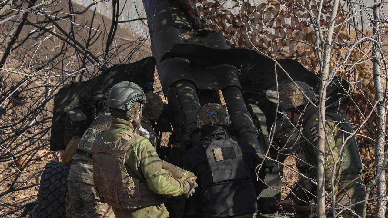 Ukrainian service members prepare a D-20 howitzer before firing toward Russian troops in Donetsk region