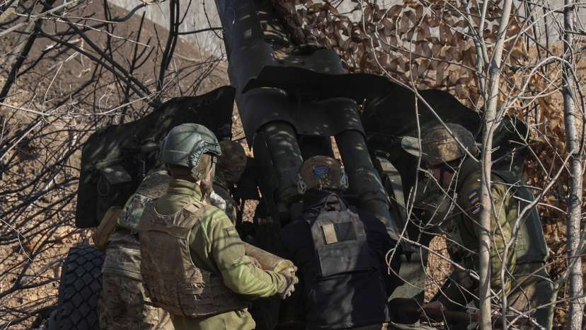 Ukrainian service members prepare a D-20 howitzer before firing toward Russian troops in Donetsk region