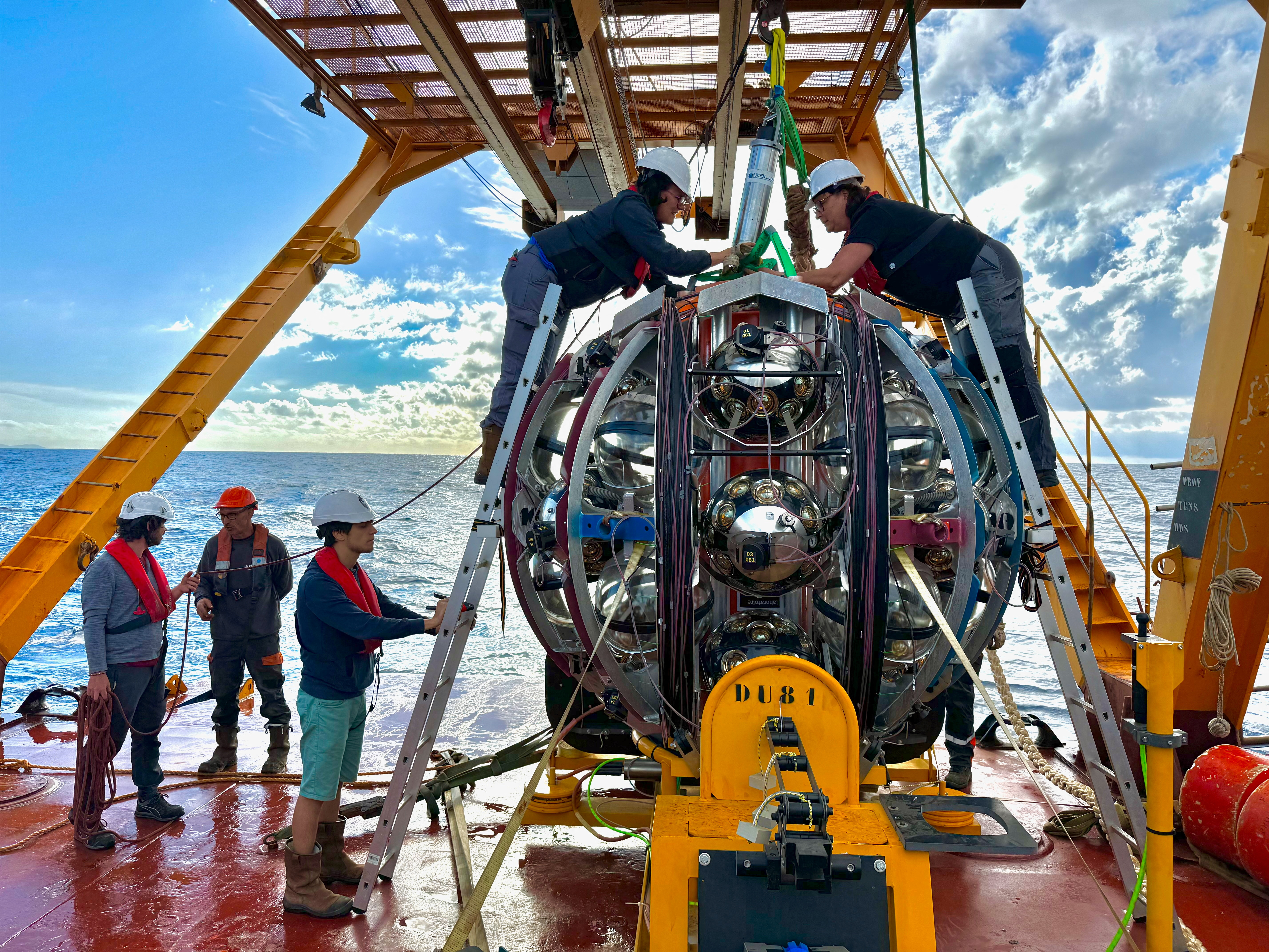 Researchers conduct final inspections on a neutrino Detection Unit (DU) aboard a research vessel to the seafloor in the Mediterranean Sea in this undated handout image