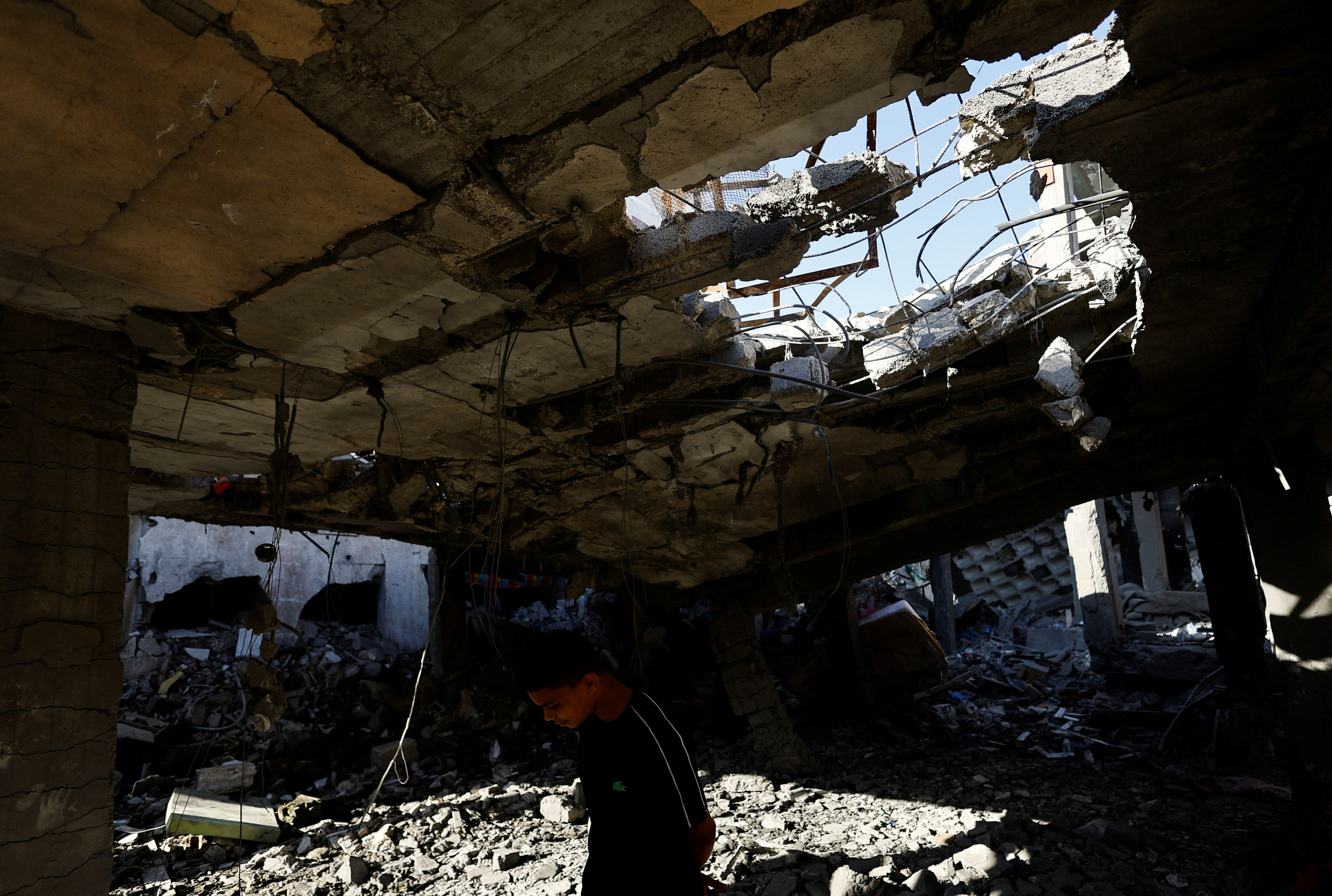 Palestinians inspect the site of an Israeli strike on a house, in Rafah