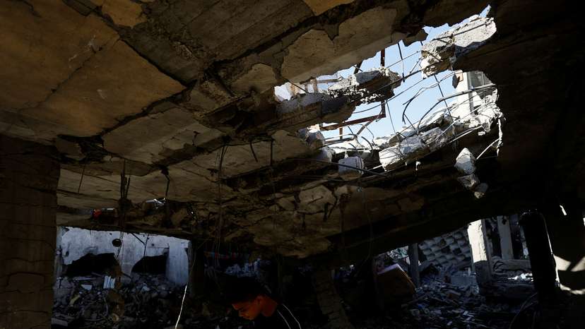 Palestinians inspect the site of an Israeli strike on a house, in Rafah